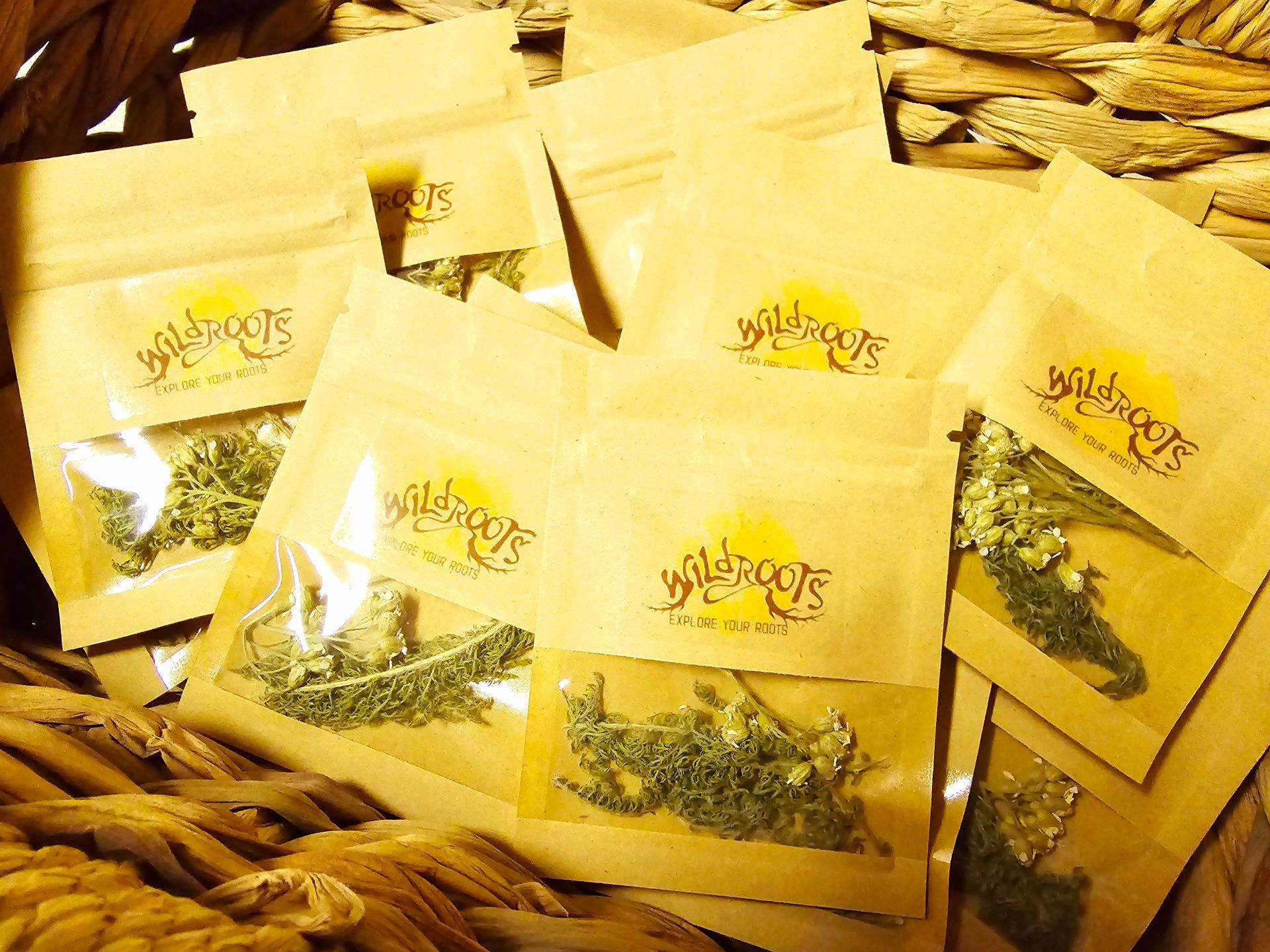 Brown paper pouches with visible herbs, logo