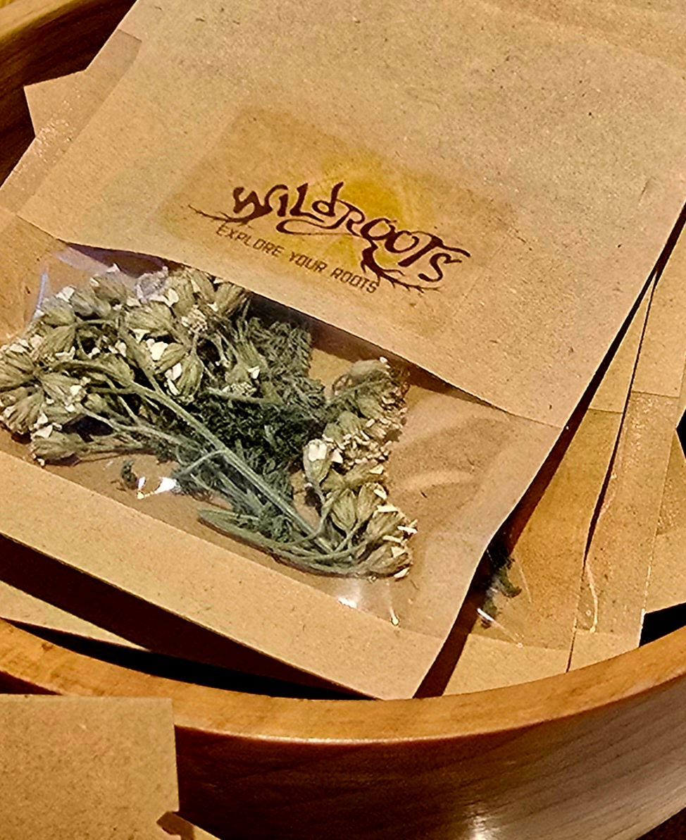 Dried herbs in a small clear pouch inside a brown paper packet with
