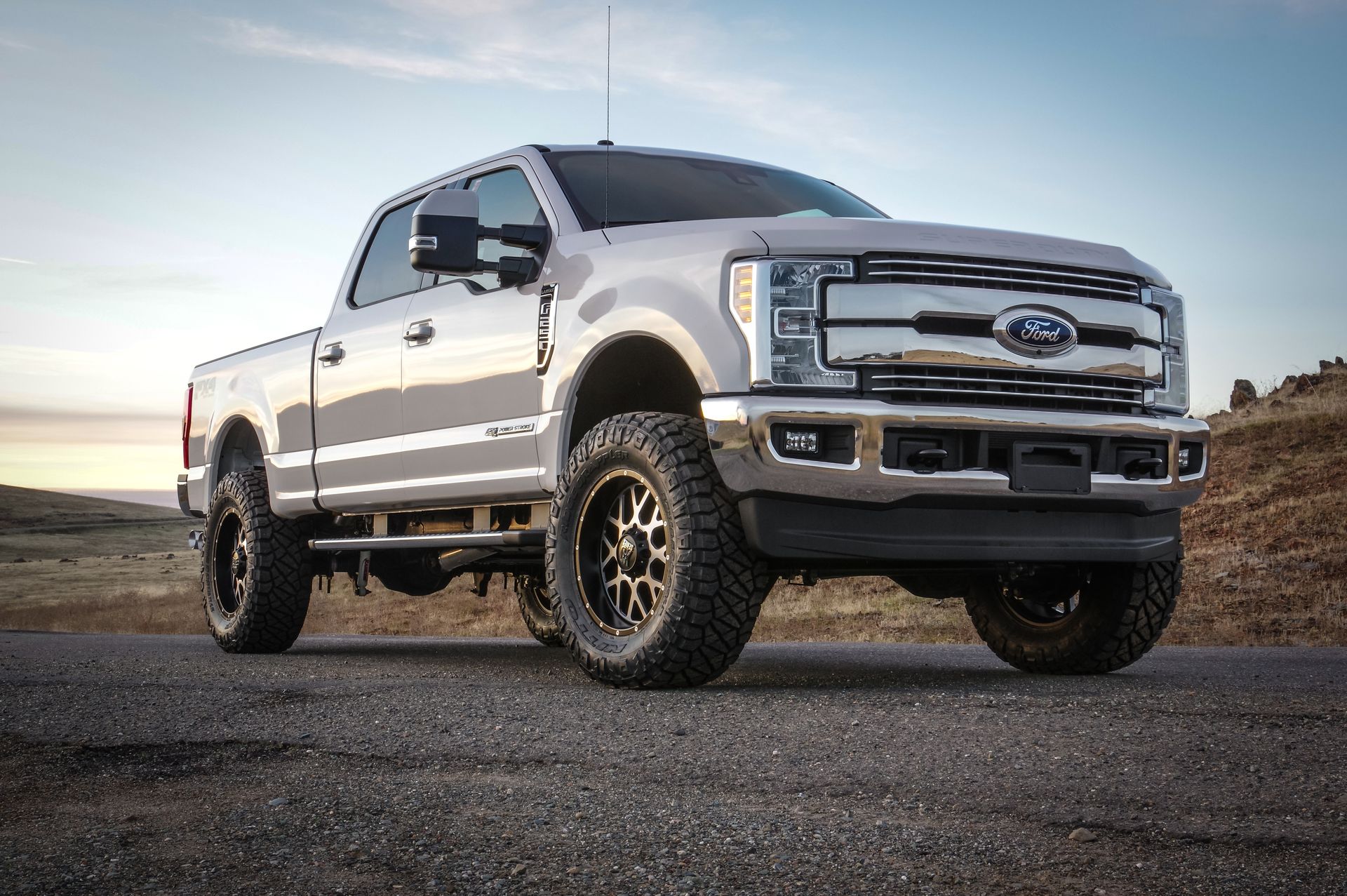 A close up of a car wheel in a parking lot.