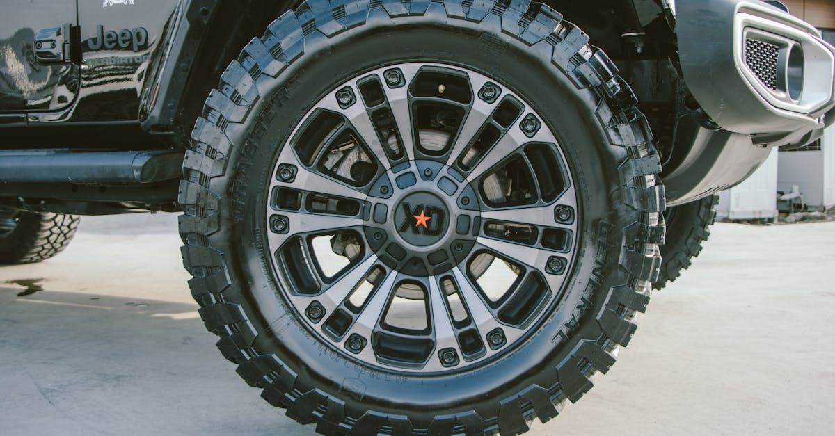 A close up of a car wheel in a parking lot.