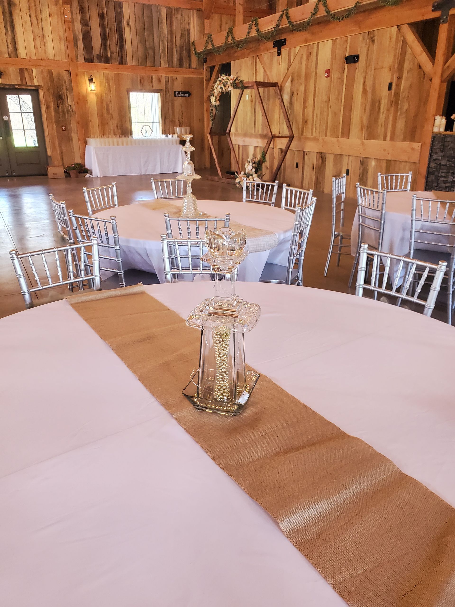 A room with tables and chairs set up for a wedding reception.