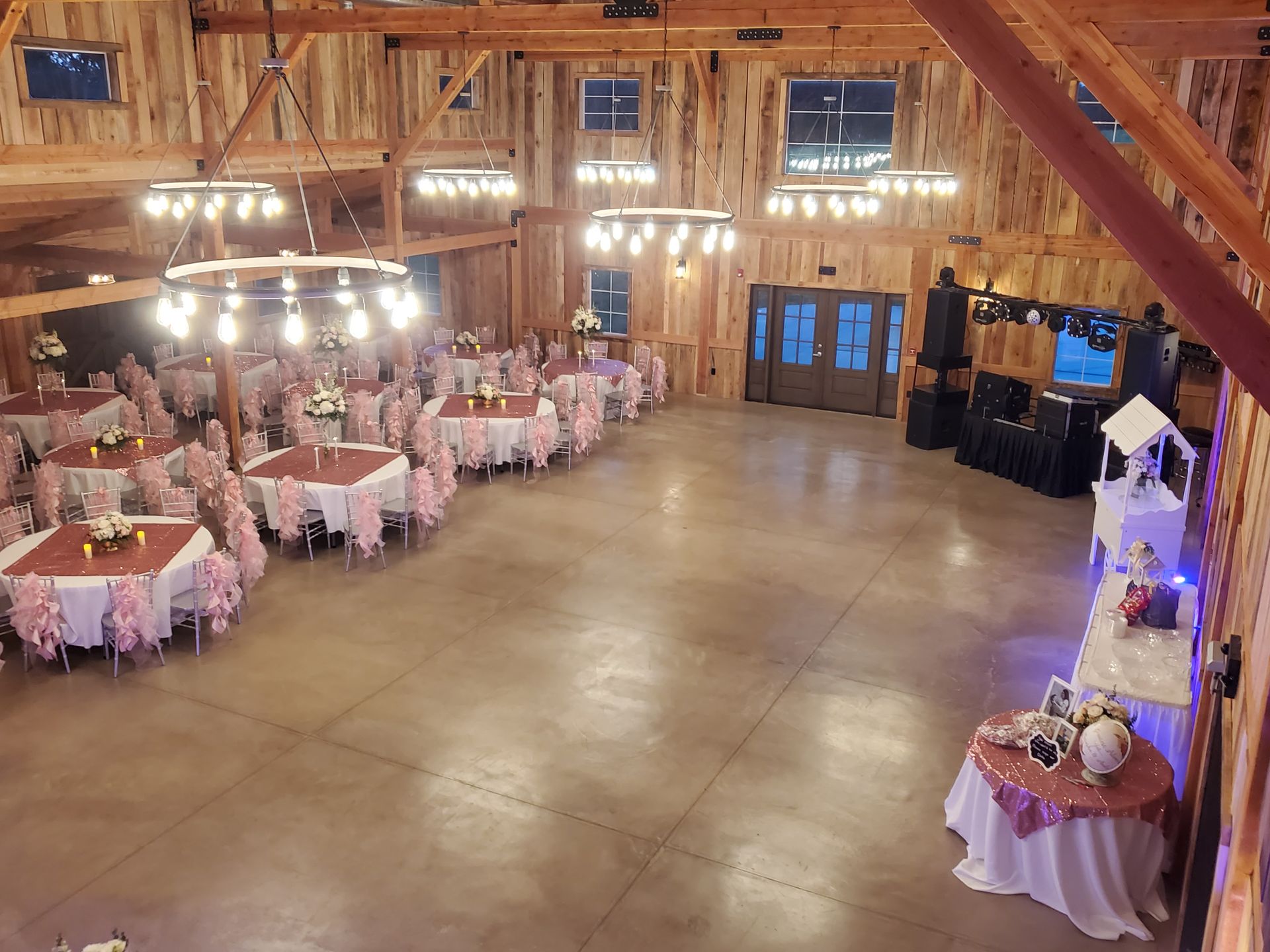 A large room with tables and chairs set up for a wedding reception.