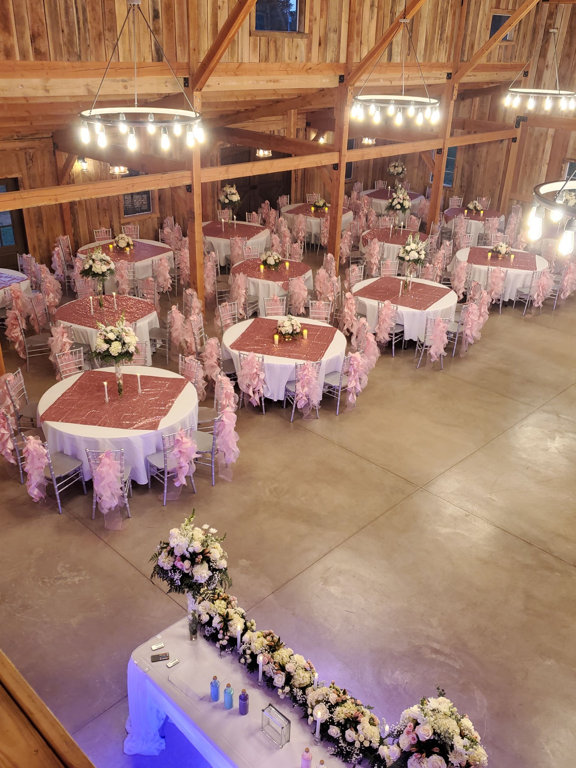 A large room filled with tables and chairs for a wedding reception.