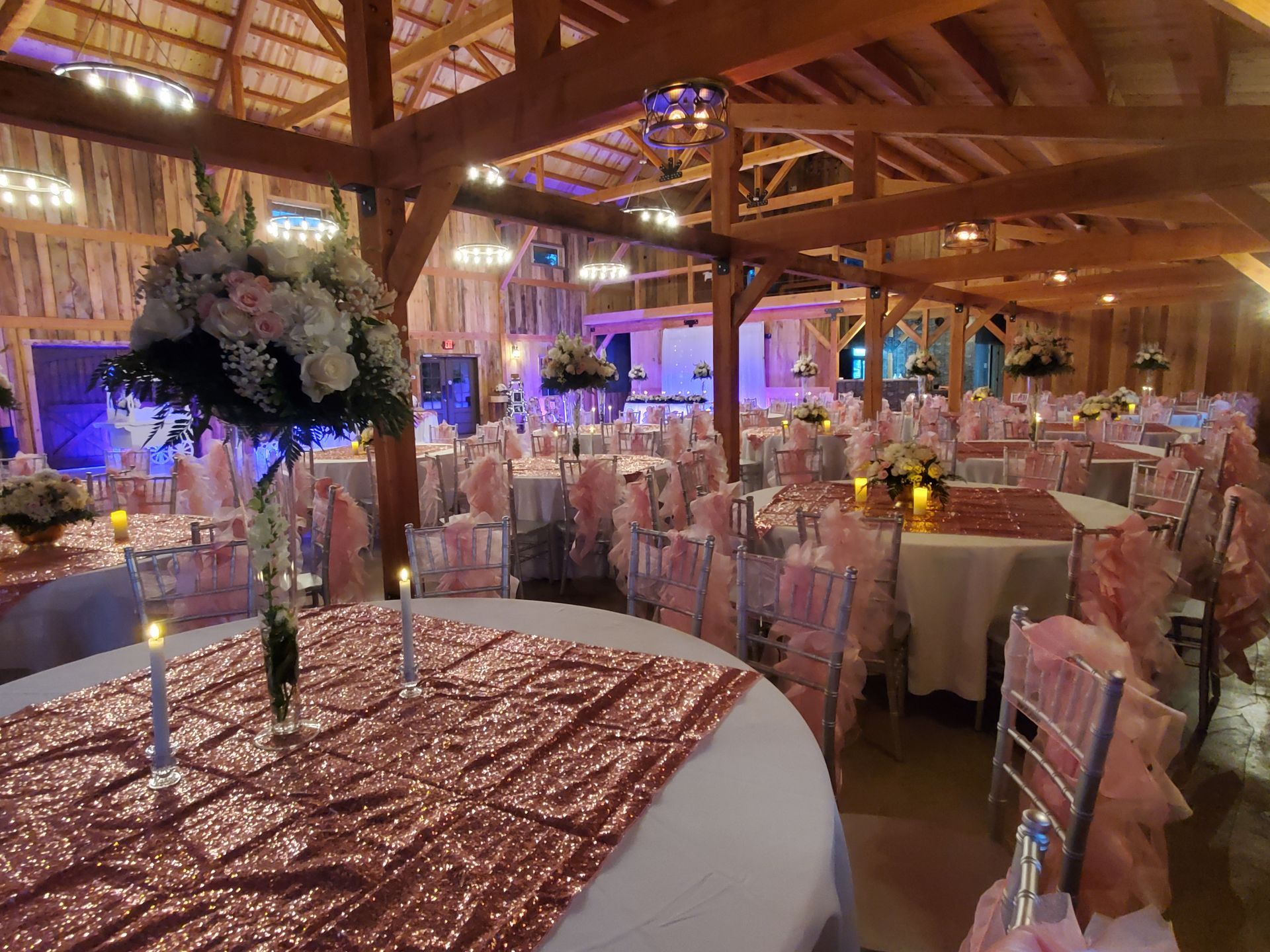 A large room with tables and chairs set up for a wedding reception.