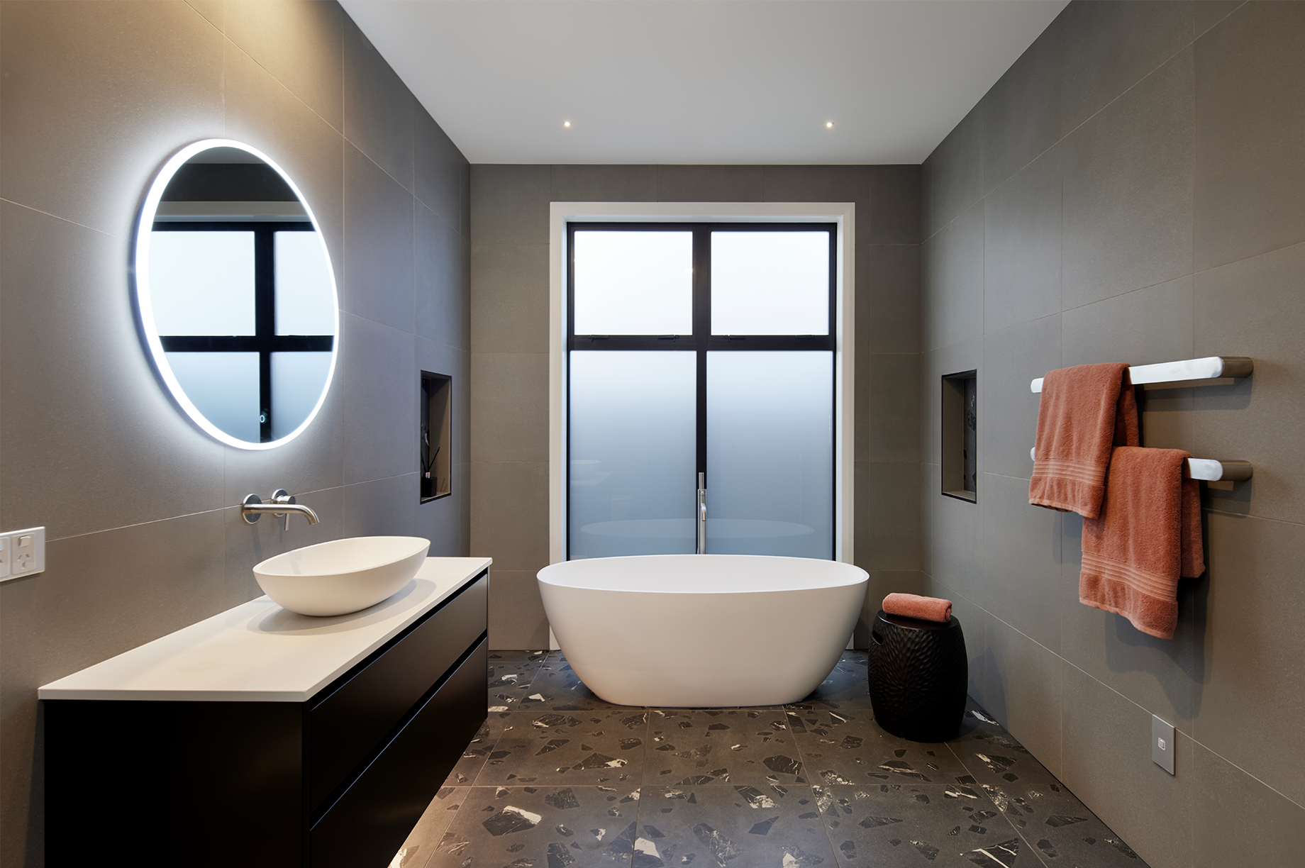 A bathroom with a tub , sink , mirror and window. Auckland Tilers