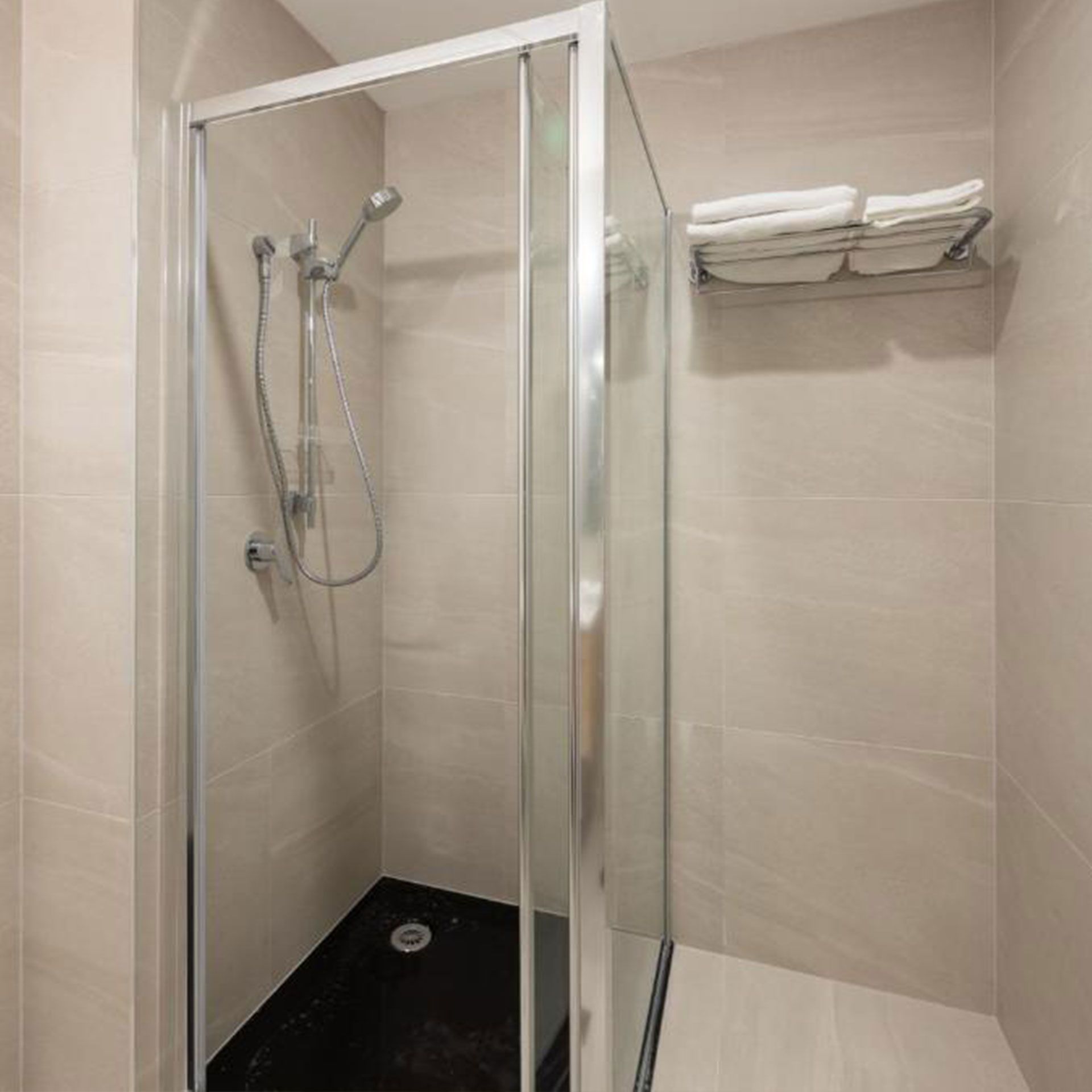 A bathroom with a shower stall and a towel rack.