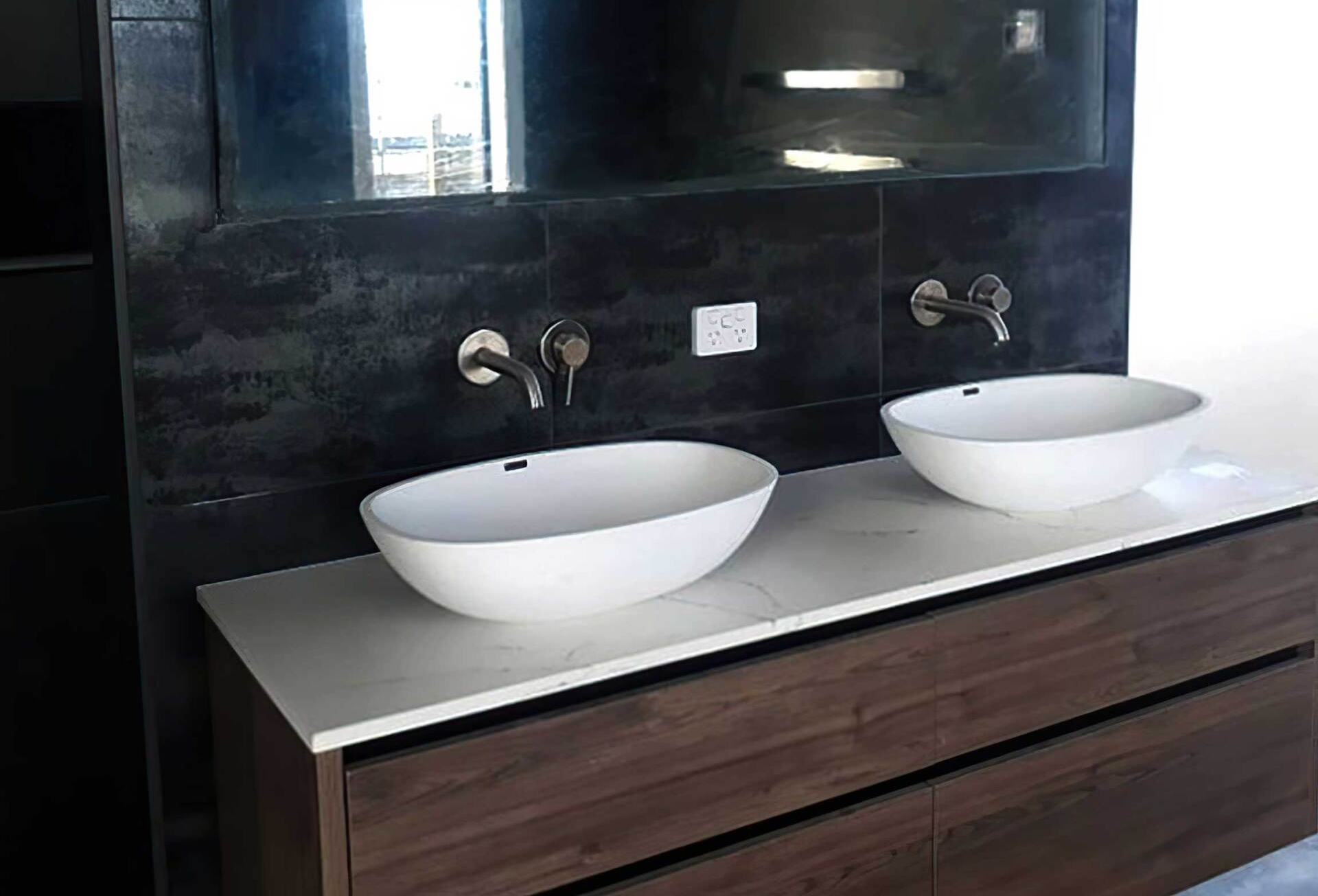 A bathroom with two sinks and a mirror. Auckland Tilers