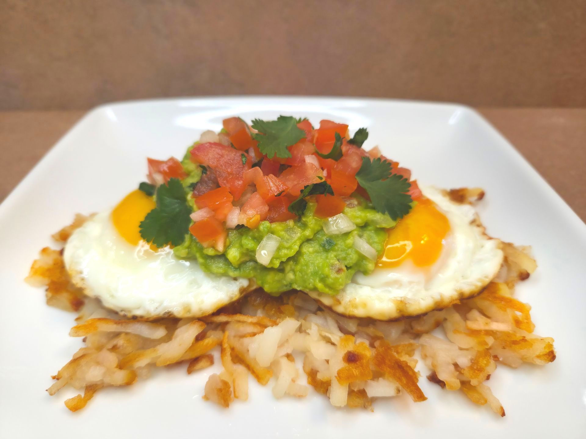 Chez Panise Happy Belly Hashbrown with fried egg, guacamole, and pico de gallow