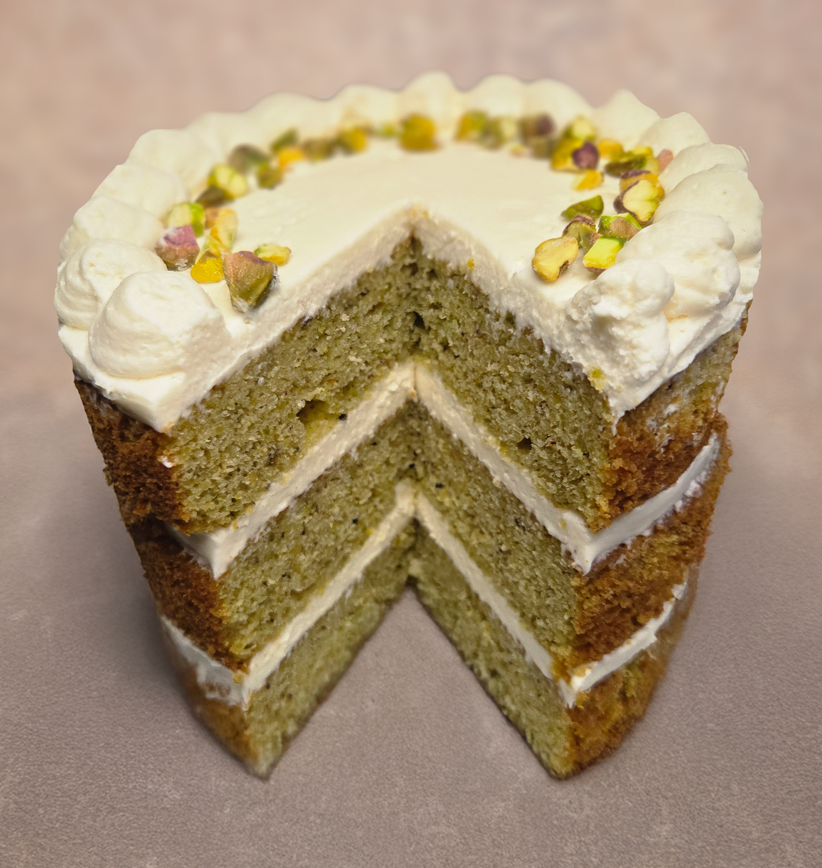 Chez Panise Pistachio Cake with a slice taken out