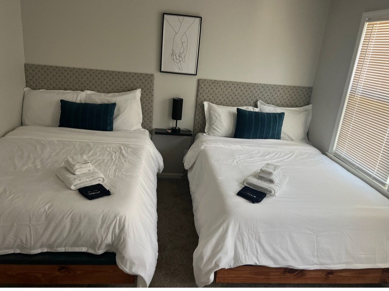 Two beds are sitting next to each other in a hotel room.