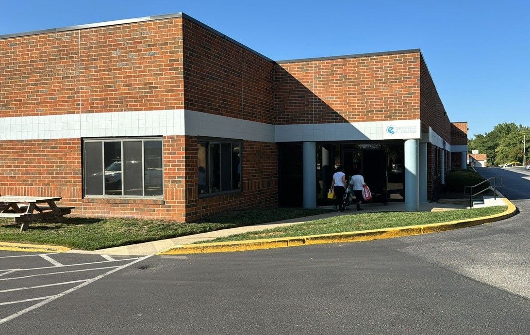 A group of people are standing outside of a brick building.