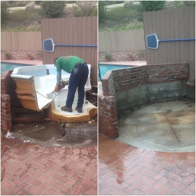 Man using a saw to remove a spa from a brick structure next to a pool.