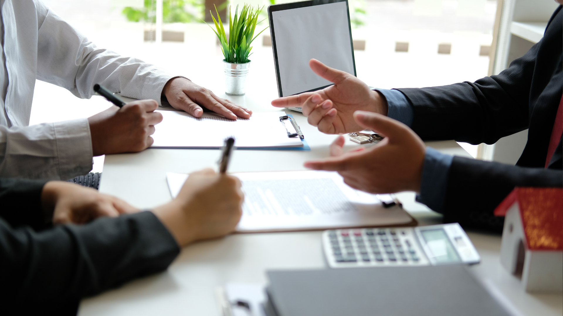 A group of people are sitting around a table having a meeting.