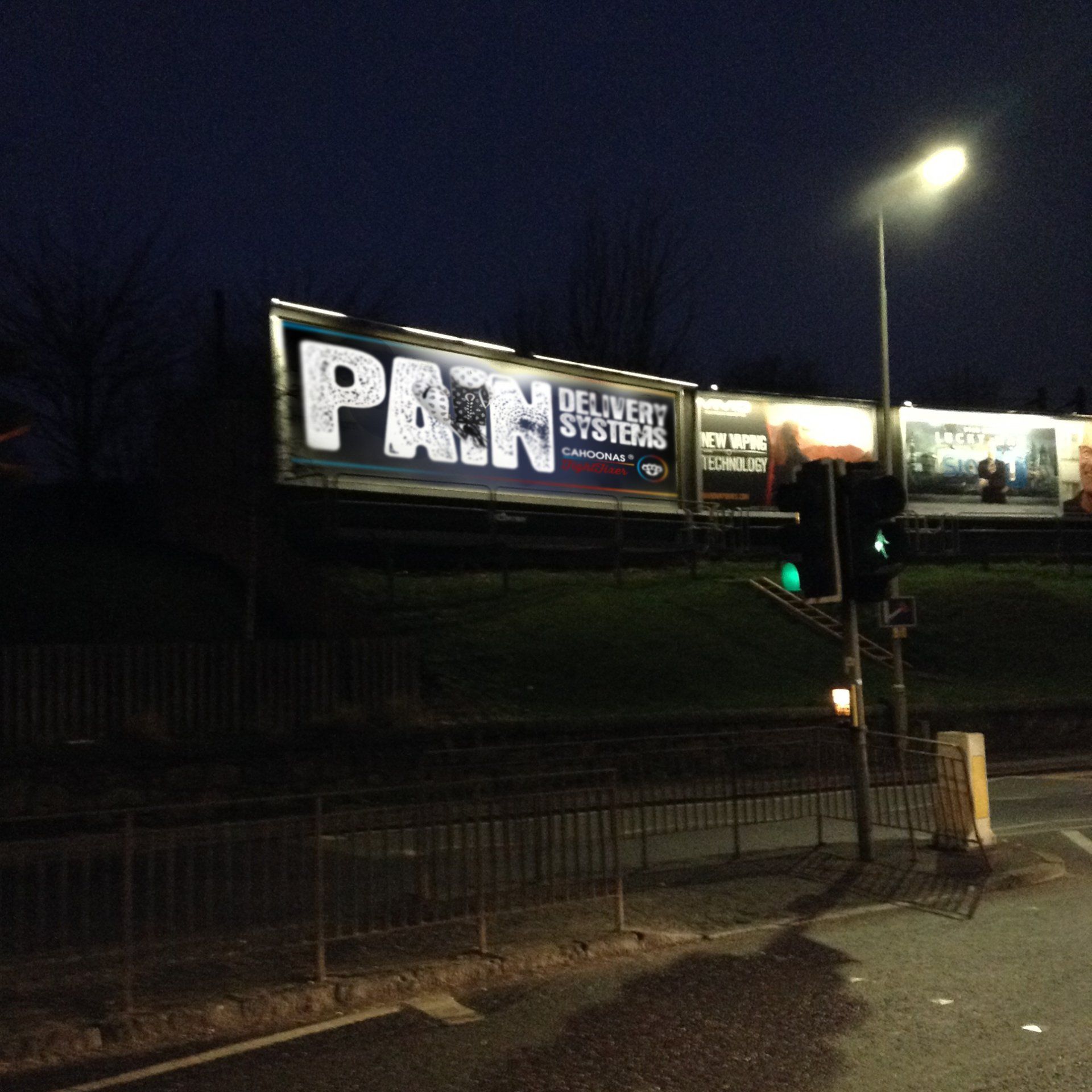 roadside poster at night features large pair of boxing gloves