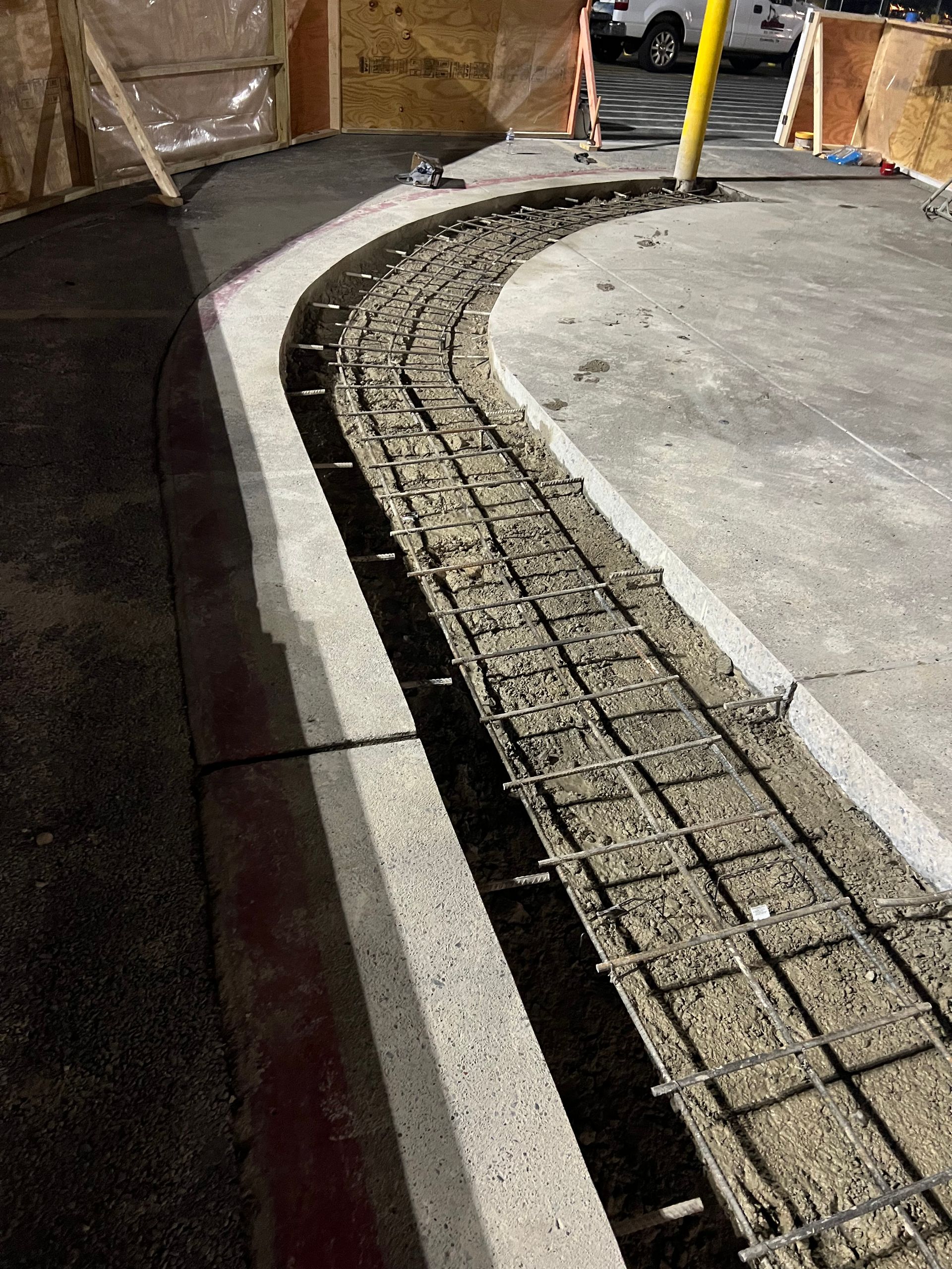 A concrete curb is being built in a parking lot.