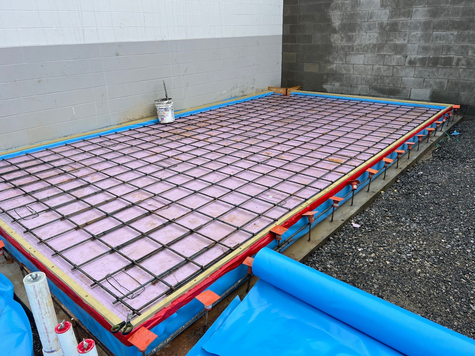 A concrete floor with a blue tarp covering it