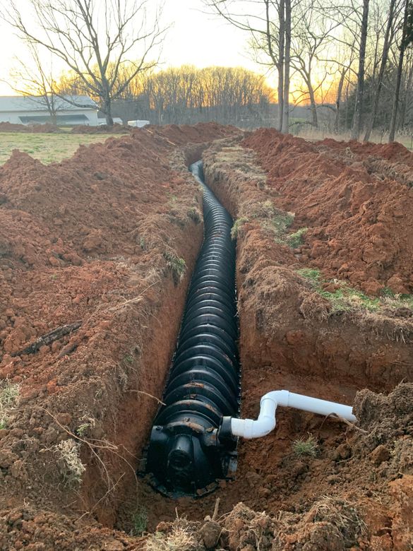 A septic tank is being installed in a hole in the ground.