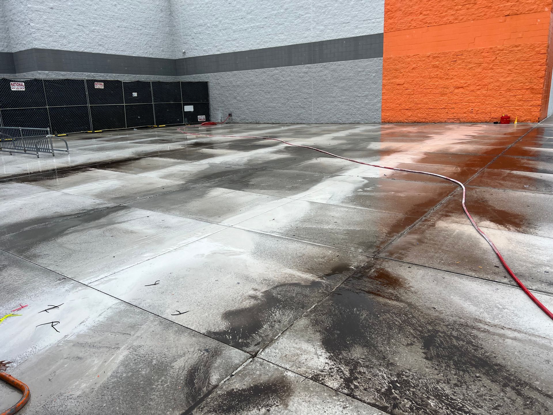 A concrete floor is being cleaned outside of a building.