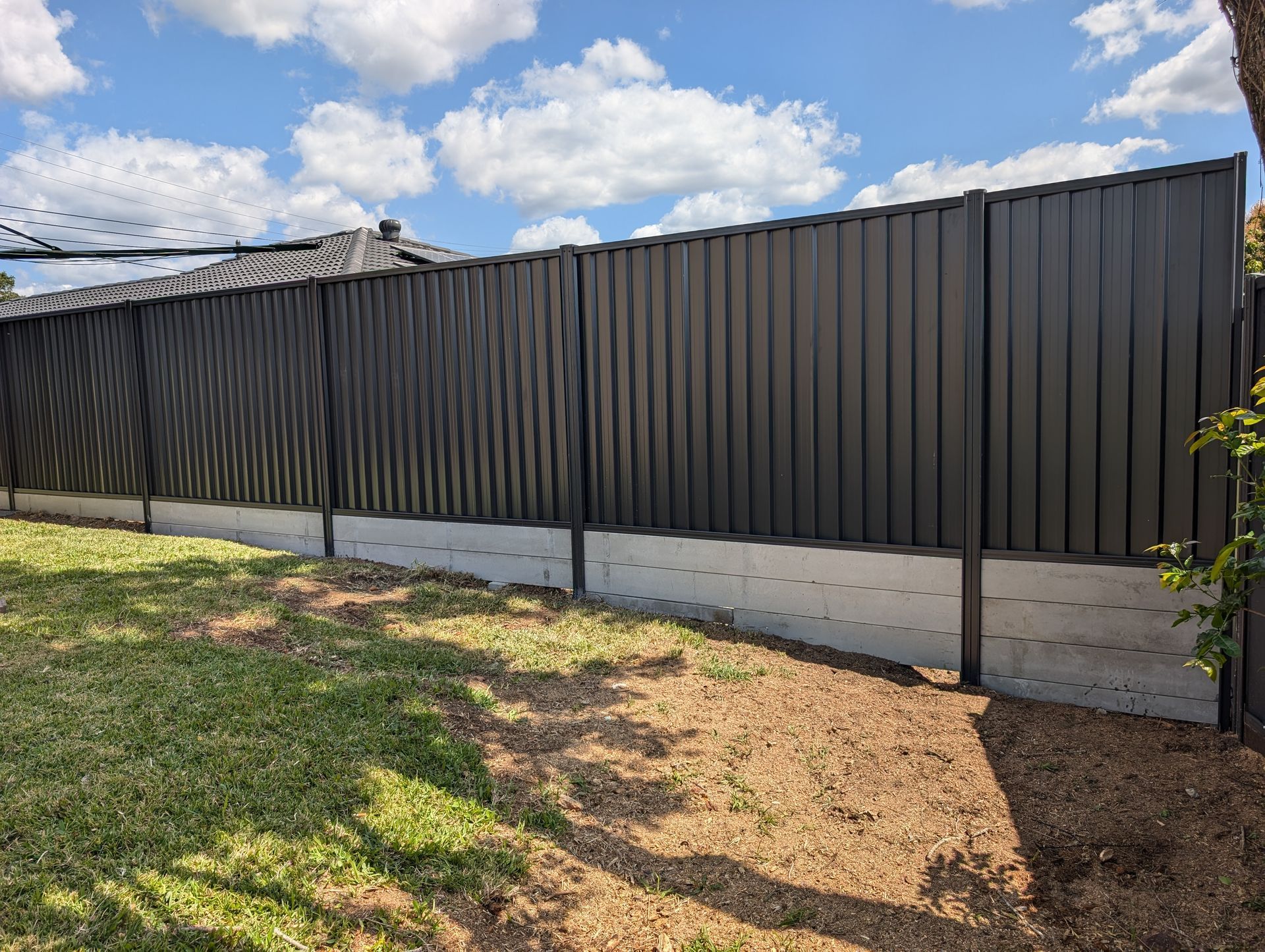 A Green Metal Fence is Surrounded by Trees and Grass — Tuff Fencing in Caboolture, QLD