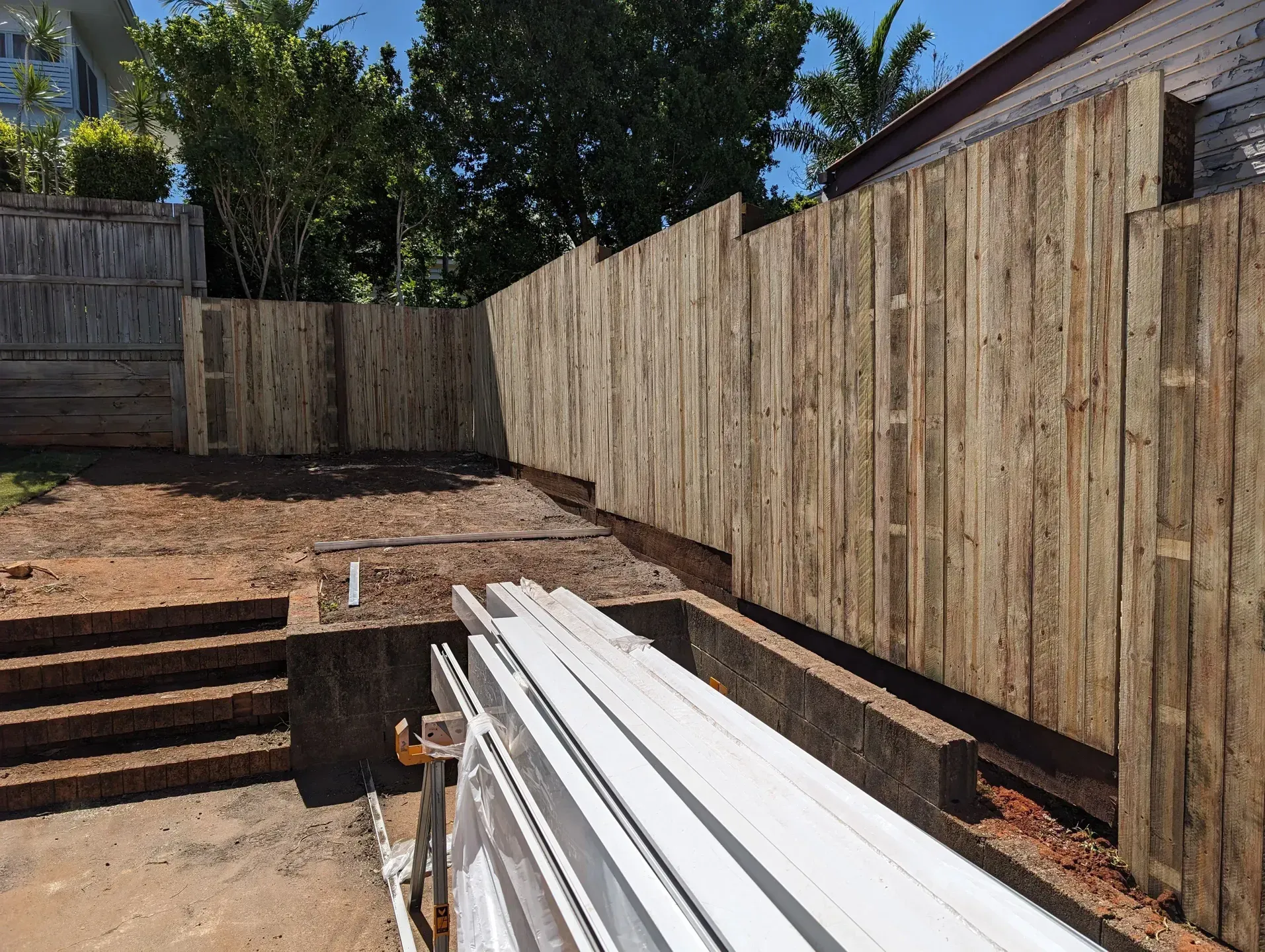 A Wooden Fence in Backyard with Brick Steps — Tuff Fencing in Caboolture, QLD