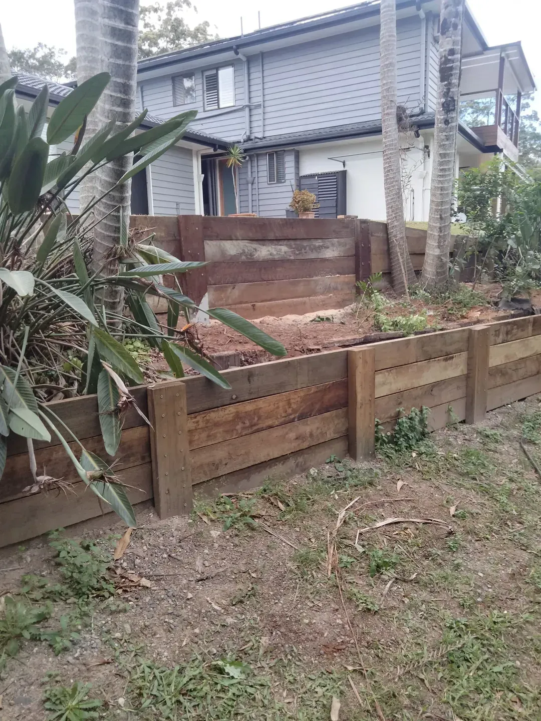 A Wooden Sleeper Wall Garden Bed in a Backyard — Tuff Fencing in Caboolture, QLD