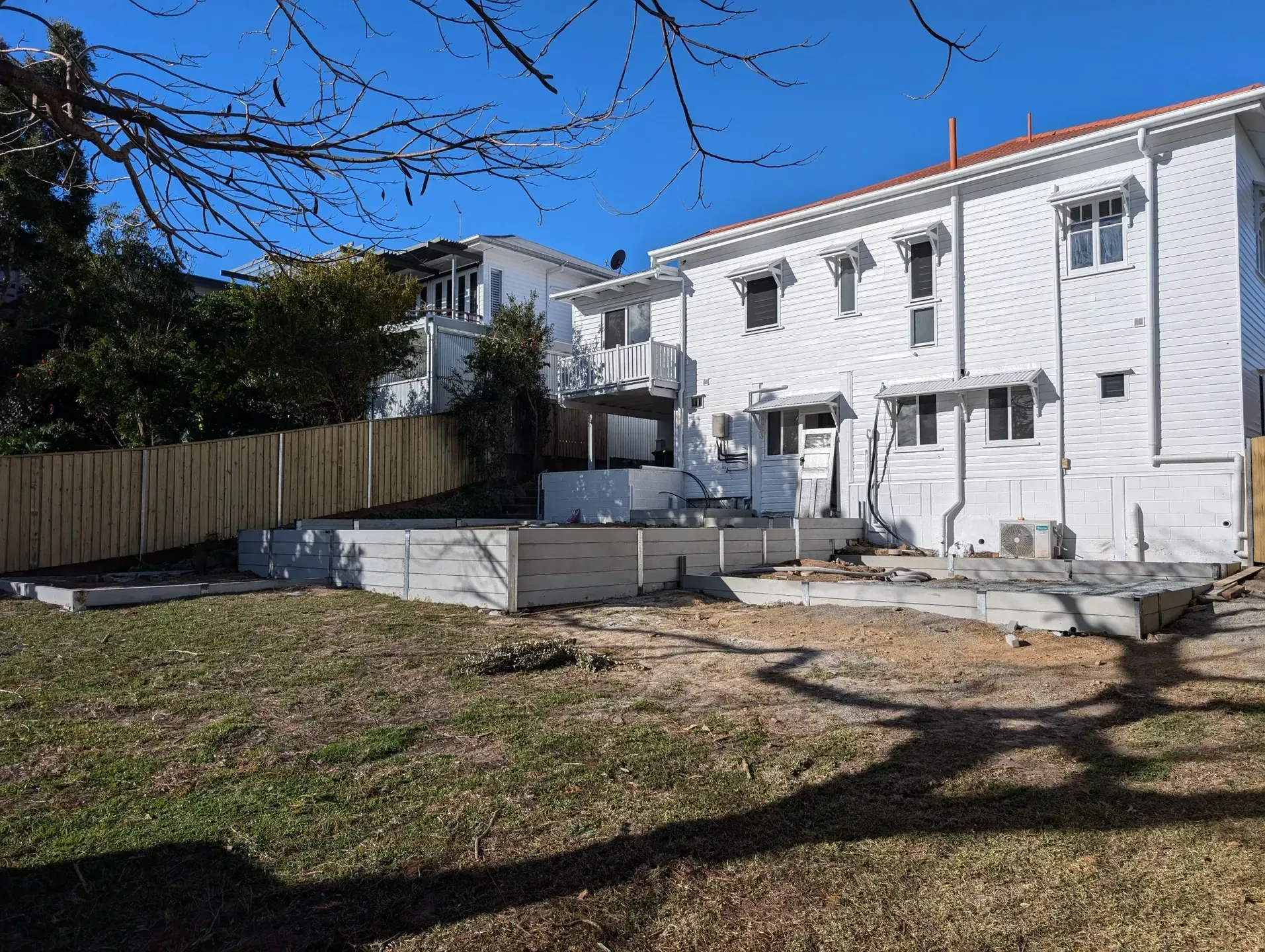 A Concrete Retaining Wall in a Backyard — Tuff Fencing in Caboolture, QLD