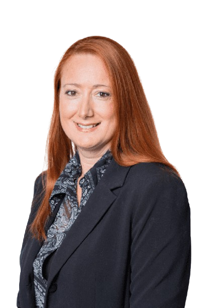Portrait of a red-haired person in a dark blazer and patterned blouse against a white background