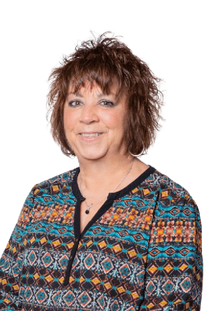 Portrait of a smiling person wearing a patterned blouse against a white background