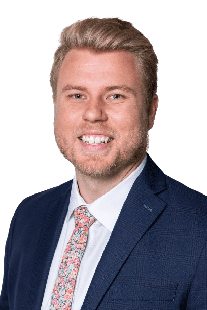 Professional headshot of a smiling man in a navy suit, white shirt, and patterned tie on a white background