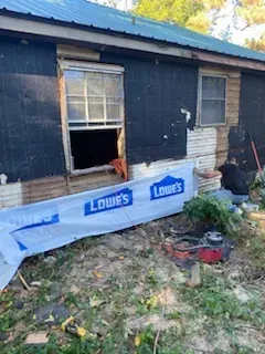 A man is working on the side of a house.