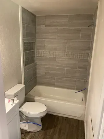 A bathroom with a toilet , bathtub and shower.