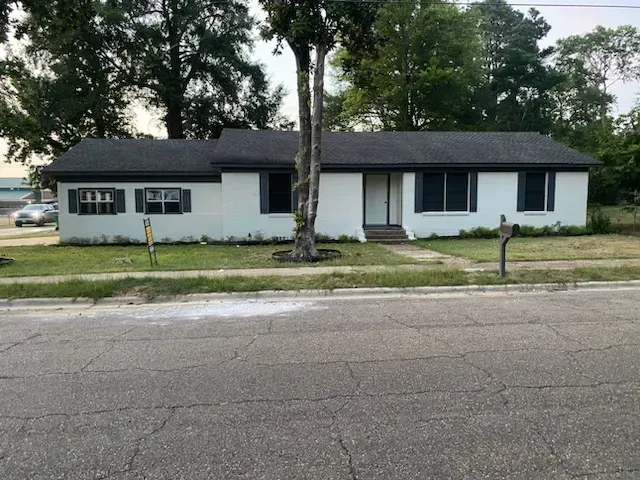 A white house with a black roof and black shutters