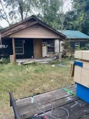A wooden table is sitting in front of a house.