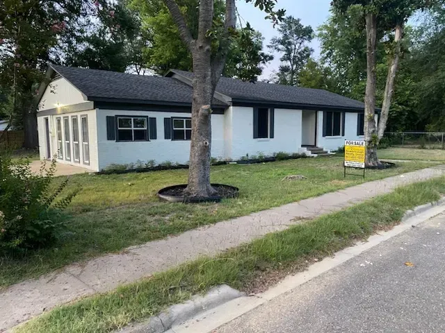 A house with a for sale sign in front of it