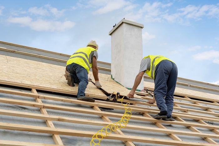 two men working on installing roofs