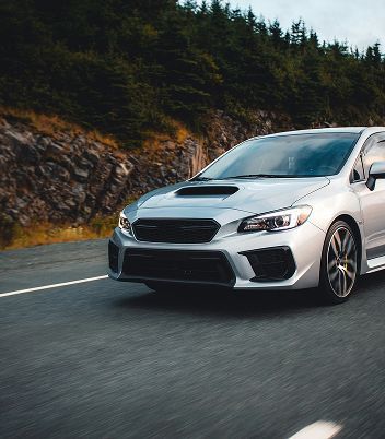 A white car on a road | American Five Star Auto Repair & Transmission