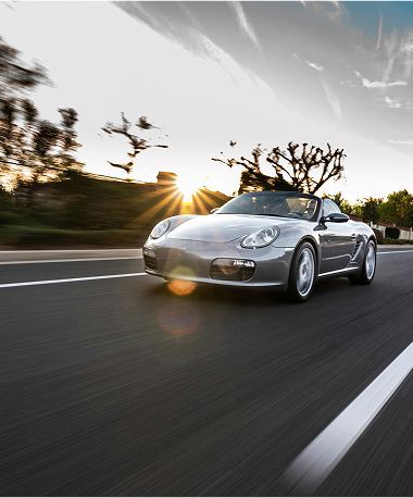 silver exotic sport coupe driving fast along a highway road | American Five Star Auto Repair & Transmission