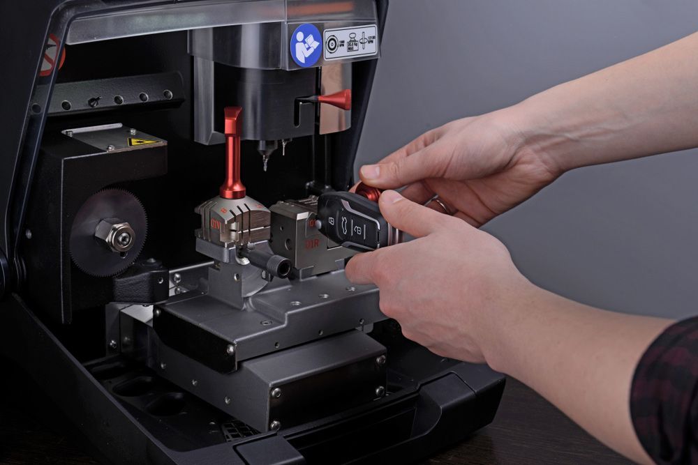 A Person is Cutting a Car Key With a Machine — The Skeleton Key Locksmiths & Security in West Tamworth, NSW