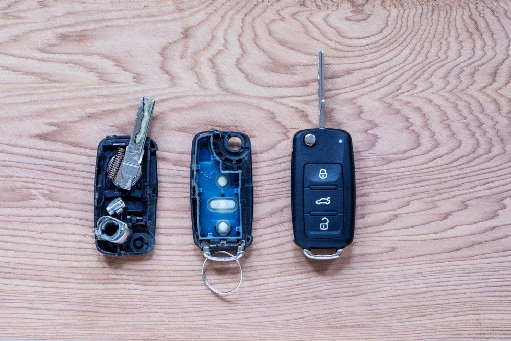 Three Car Keys Are Sitting on a Wooden Table — The Skeleton Key Locksmiths & Security in West Tamworth, NSW