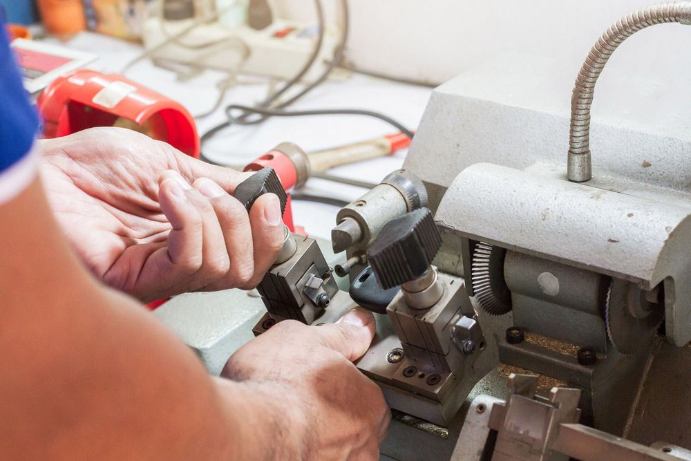 A Man is Using a Machine to Make a Key — The Skeleton Key Locksmiths & Security in West Tamworth, NSW