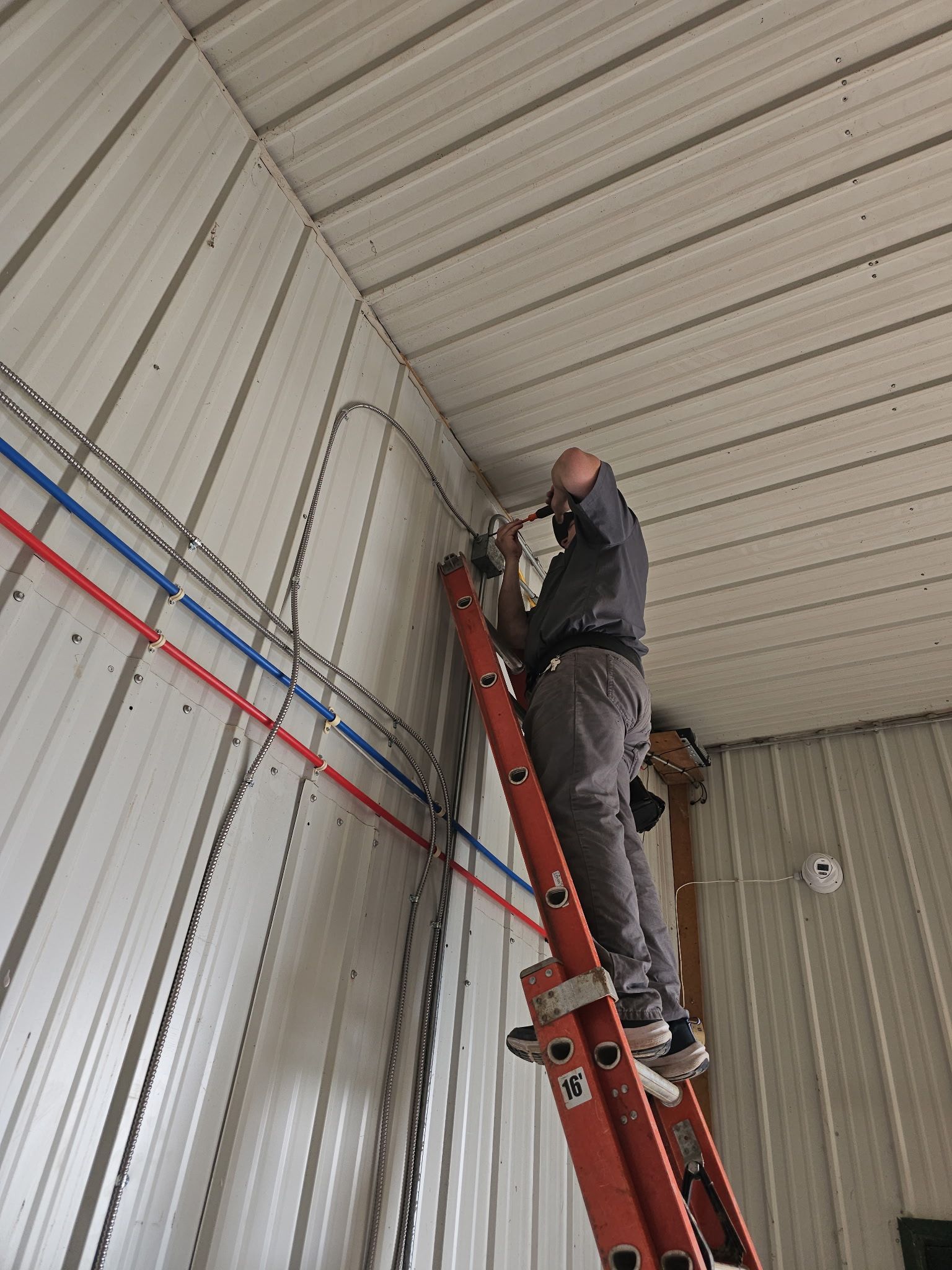 A man is standing on a ladder in a building.