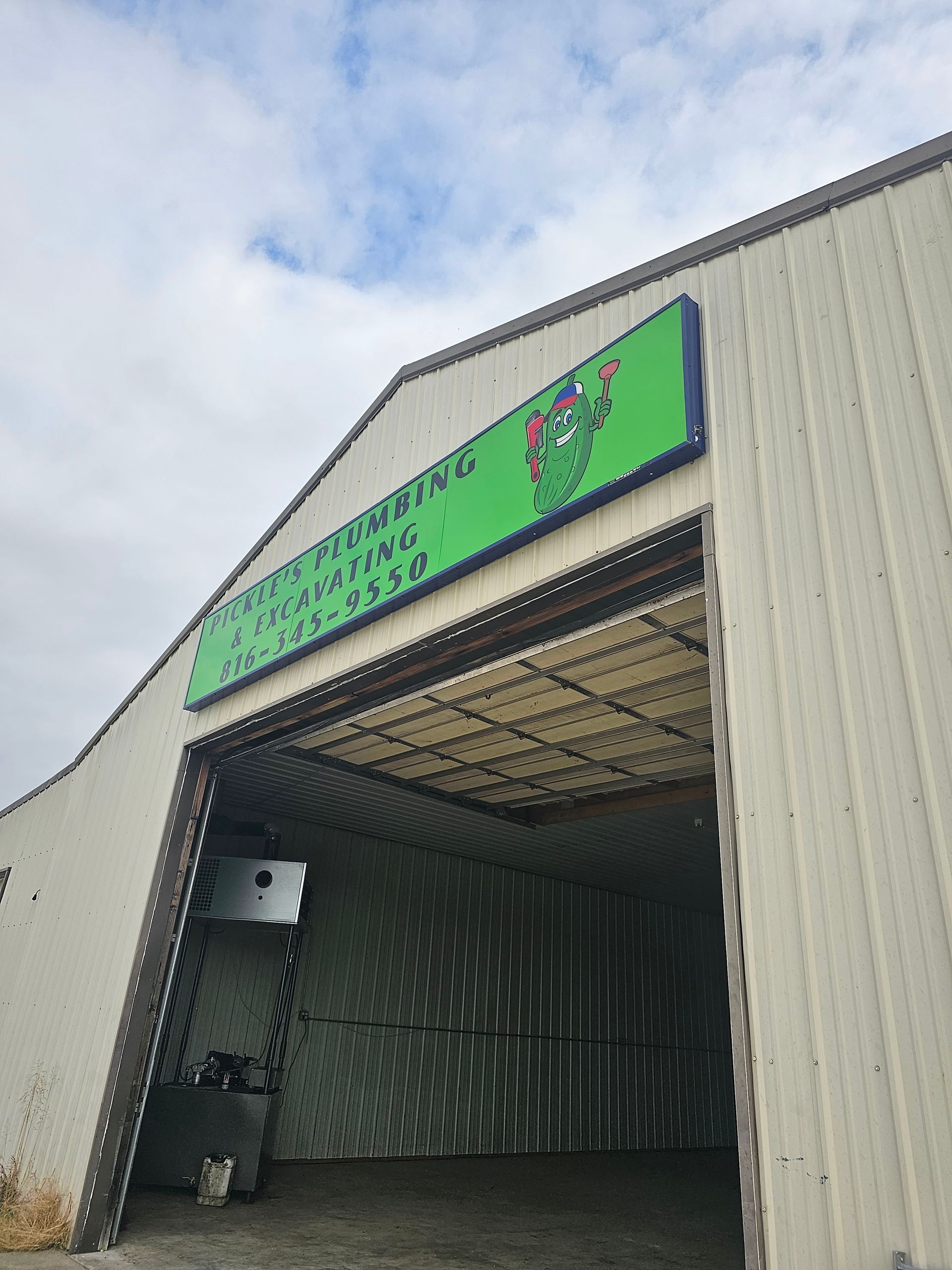 A white building with a green sign on the front of it.