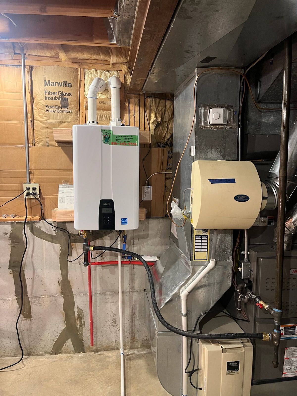 A gas water heater is installed in a basement next to an air conditioner.