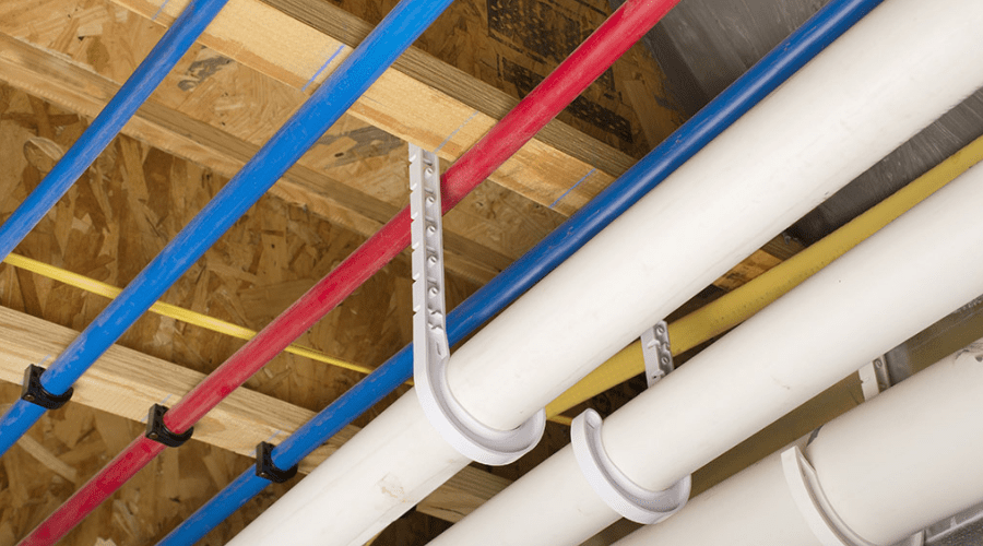 A bunch of pipes are hanging from the ceiling in a room.