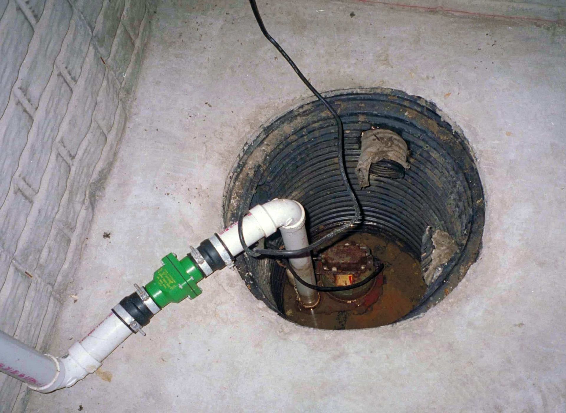 A drain with a green valve attached to it