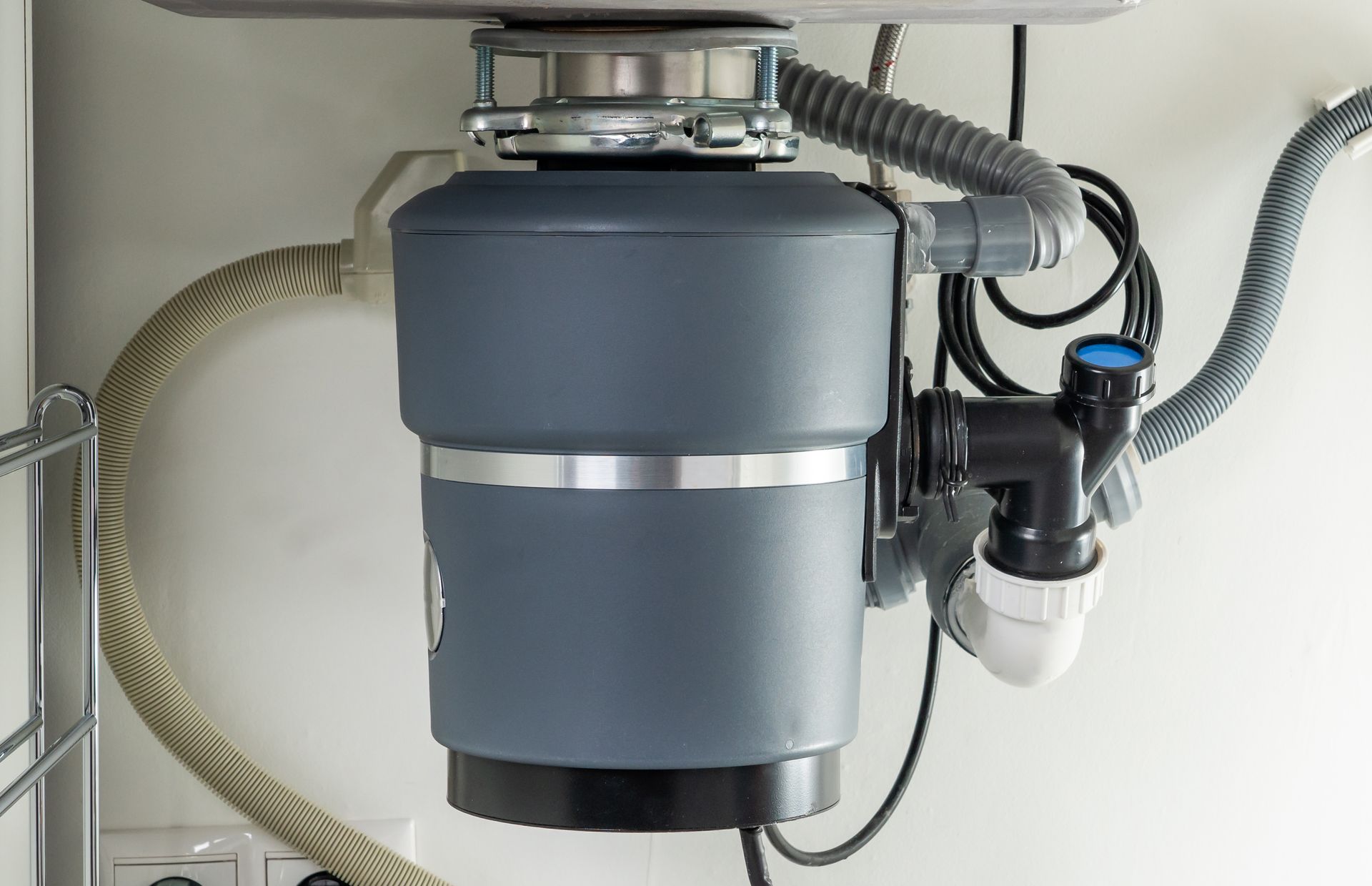 A garbage disposal is sitting under a sink in a kitchen.