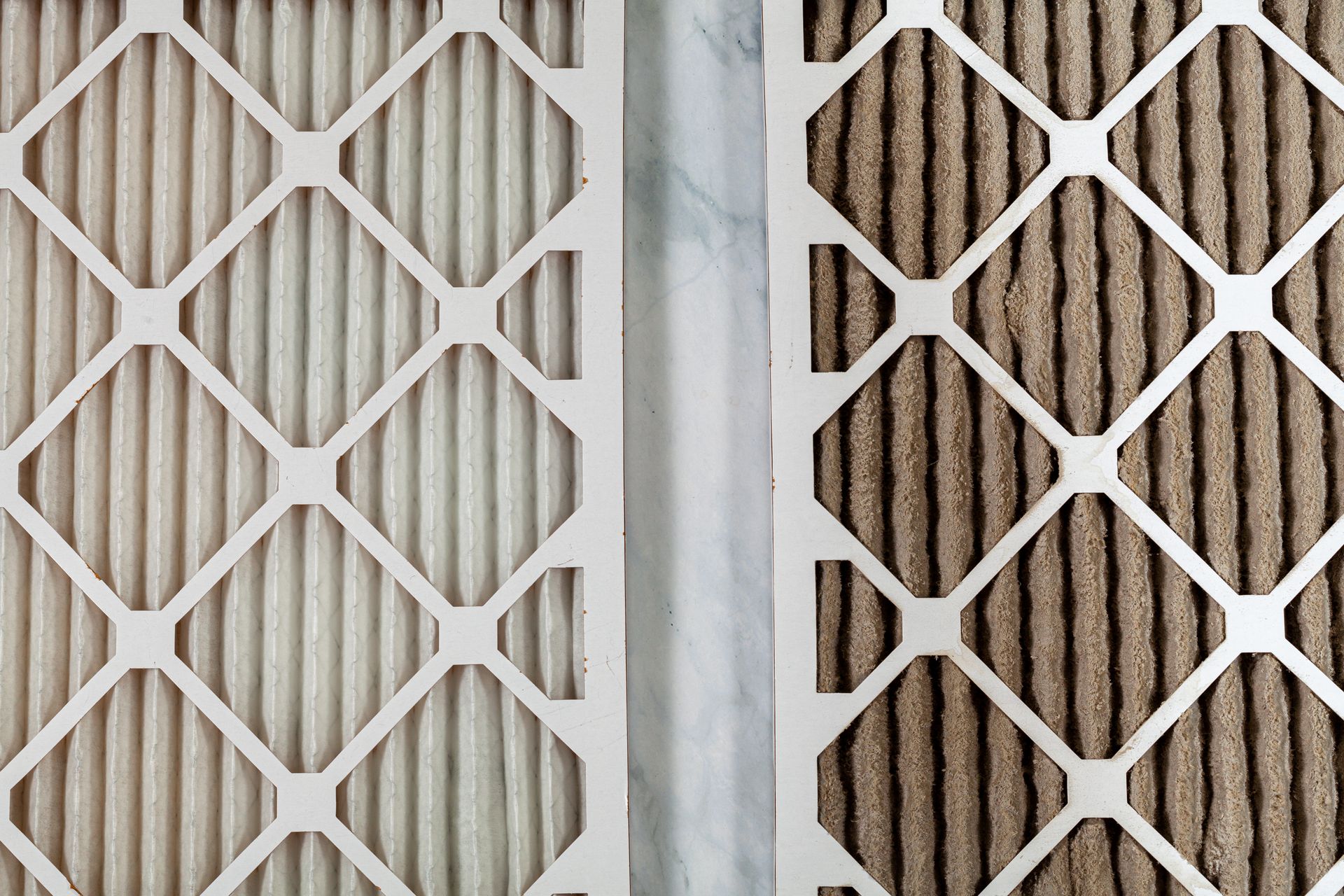 Side-by-side comparison of a clean, white HVAC air filter and a dirty, brown used filter.