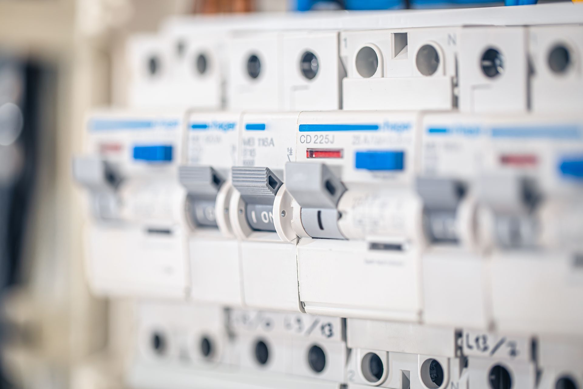 Close-up of a white electrical fuse box with multiple switches in the on position.