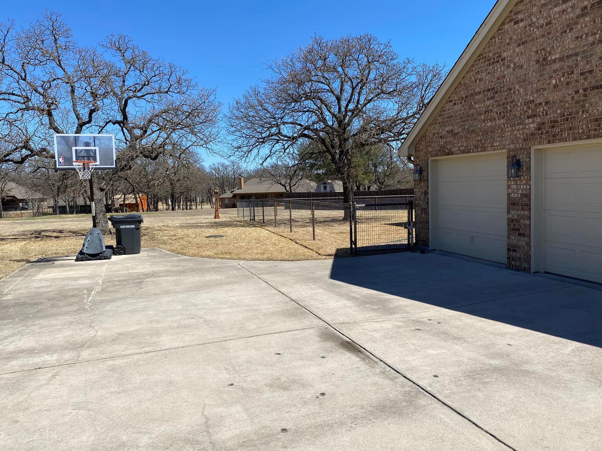 There is a basketball hoop in the driveway of a house.
