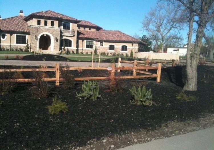 A large house with a wooden fence in front of it